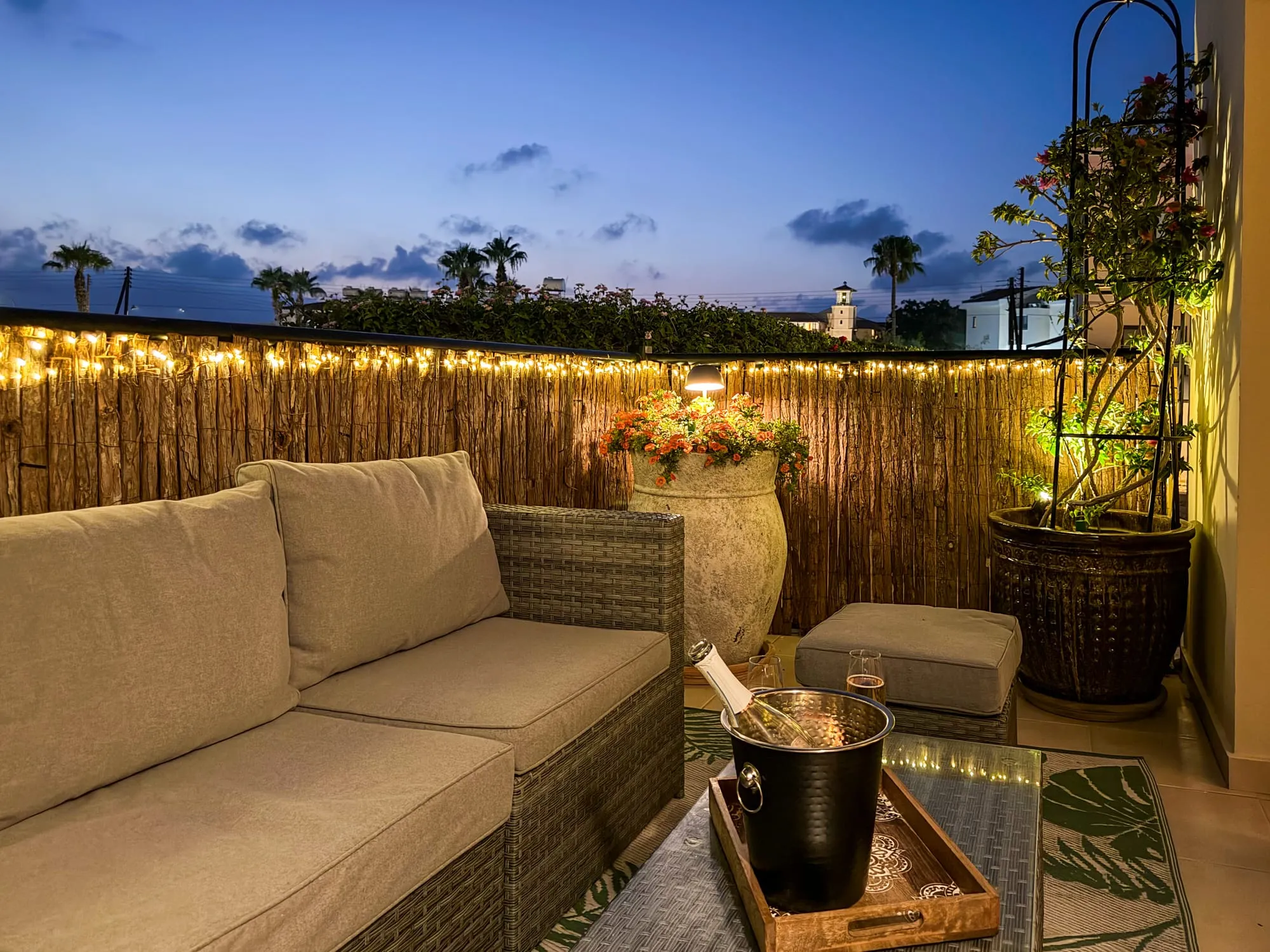 The front patio at dusk, lit with string lights, the lighthouse on the horizon