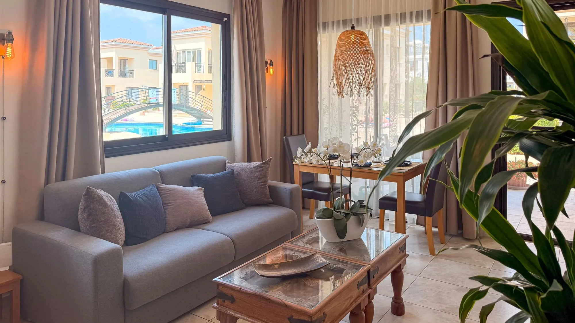The living room, with the pool framed in the window behind the sofa